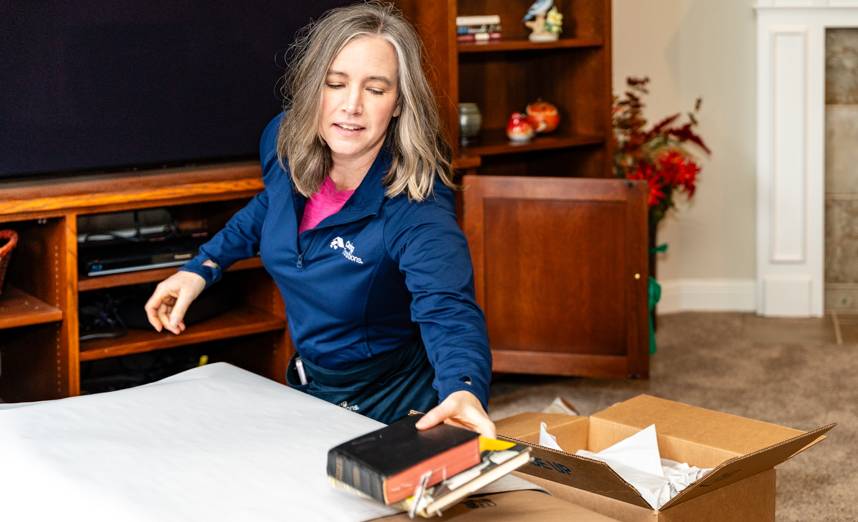 Caring Transitions specialist packing books and belongings during a Gilbert home decluttering project