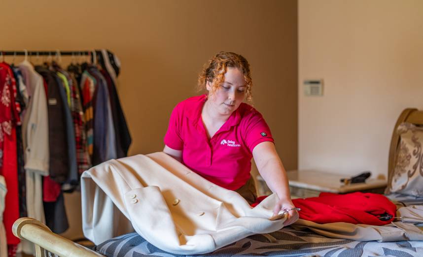 Decluttering specialist sorting clothing in a Gilbert senior's bedroom