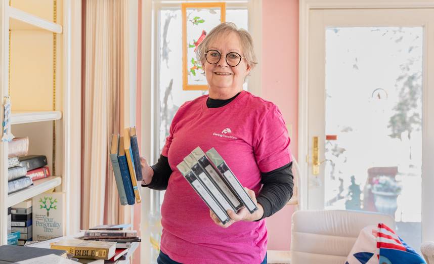 Caring Transitions team member sorting books and media during a Gilbert decluttering project