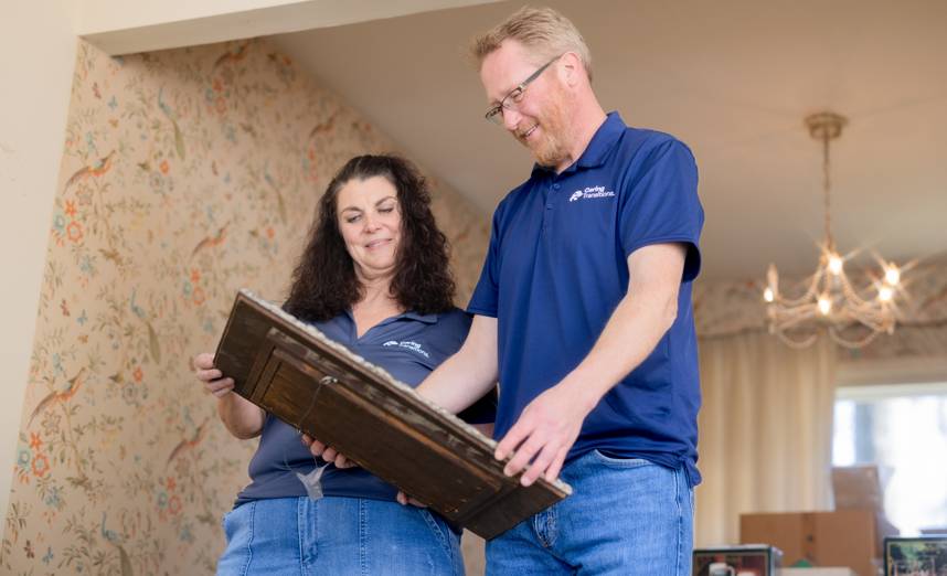 Caring Transitions estate sale specialists examining an antique chest in a Bethesda home