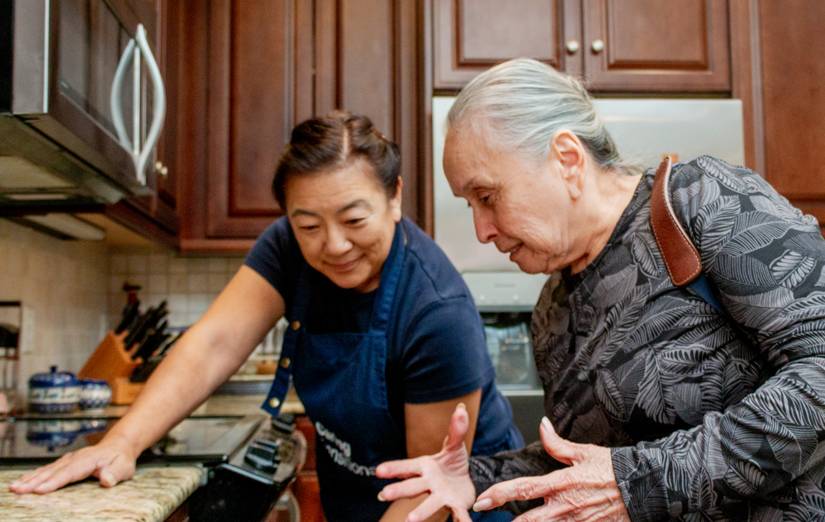 Caring Transitions specialist helping a senior sort kitchen belongings during a Arlington relocation